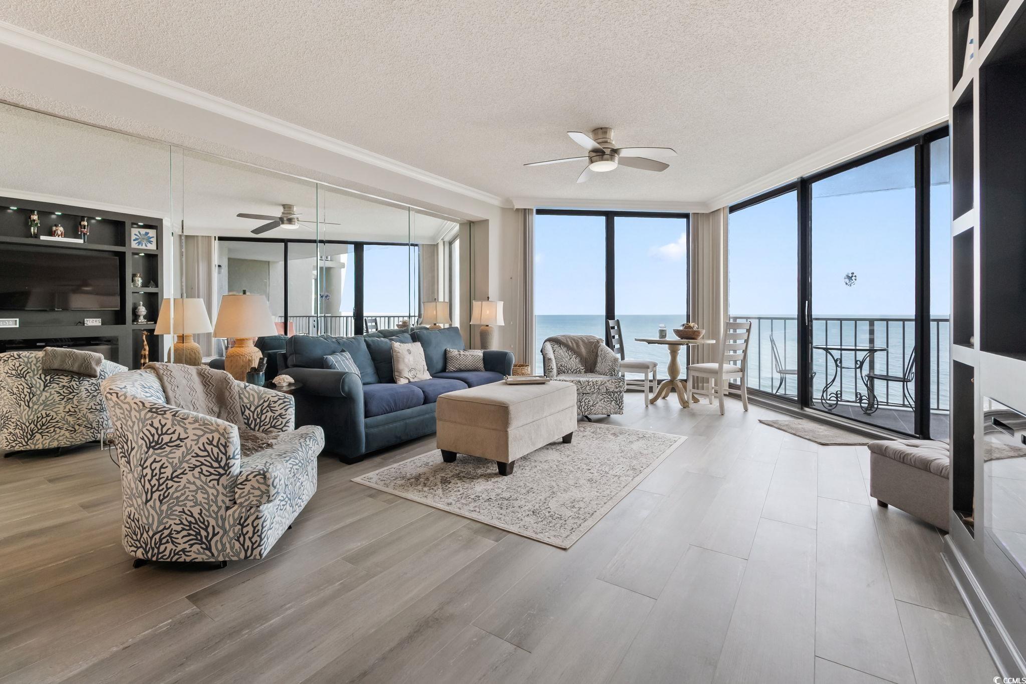 1990 North Waccamaw Drive, Unit 403 Murrells Inlet, SC 29576 - Photo 6 of 39 Living area featuring floor to ceiling windows, a textured ceiling, a water view, ceiling fan, and wood finished floors