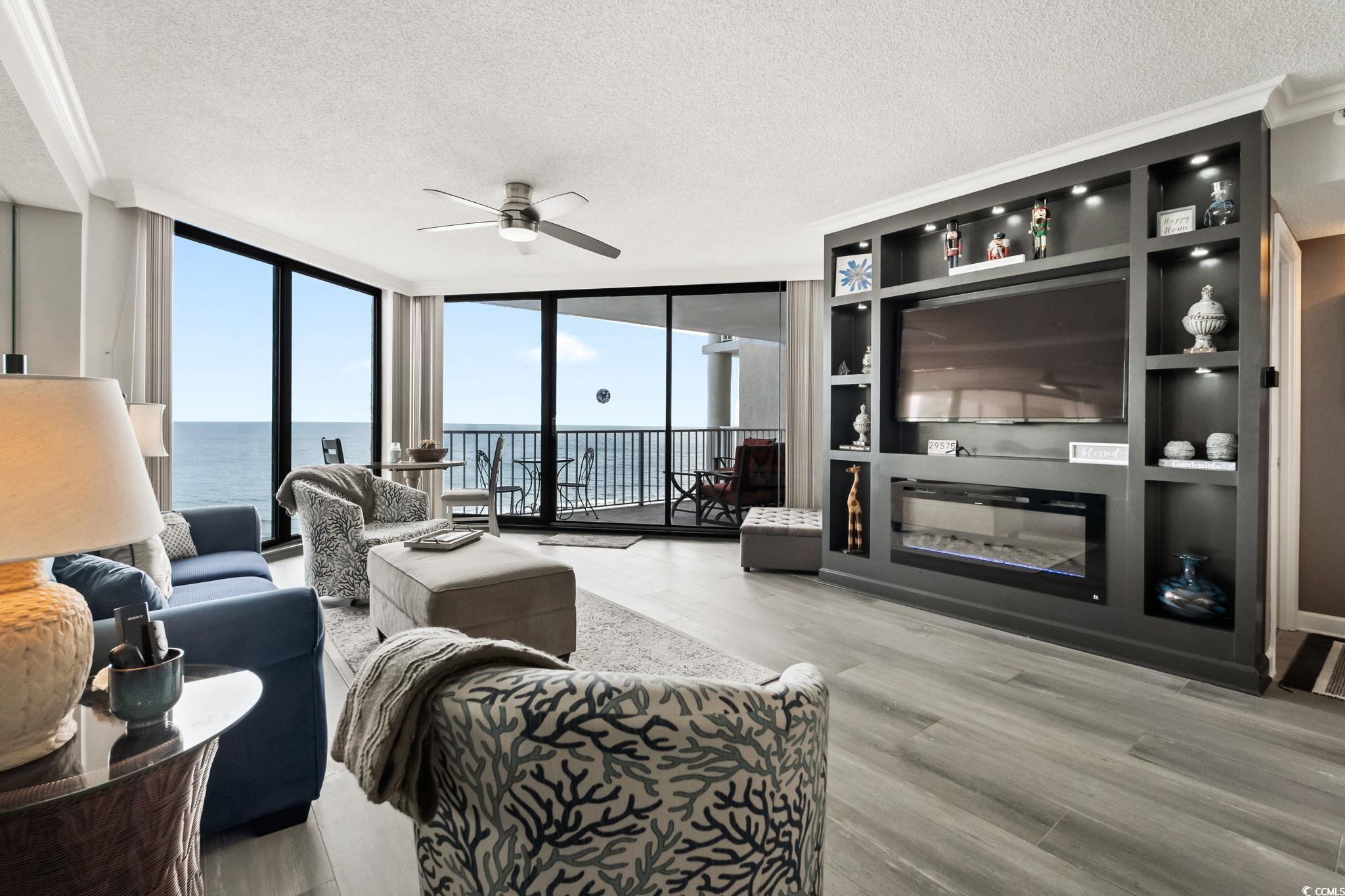 1990 North Waccamaw Drive, Unit 403 Murrells Inlet, SC 29576 - Photo 7 of 39 Living room featuring expansive windows, a textured ceiling, light wood-type flooring, and a ceiling fan