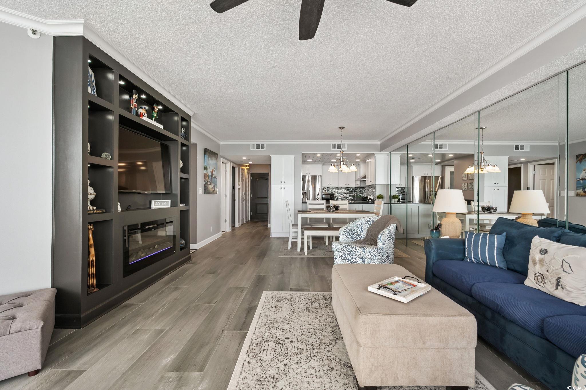 1990 North Waccamaw Drive, Unit 403 Murrells Inlet, SC 29576 - Photo 10 of 39 Living area featuring ornamental molding, wood finished floors, a ceiling fan, a chandelier, and a textured ceiling