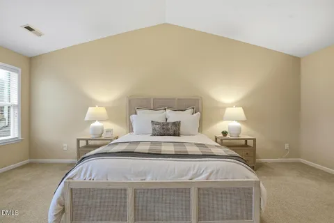 a spacious bedroom with a bed and a lamp
