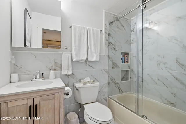 a bathroom with a granite countertop sink and a bathtub