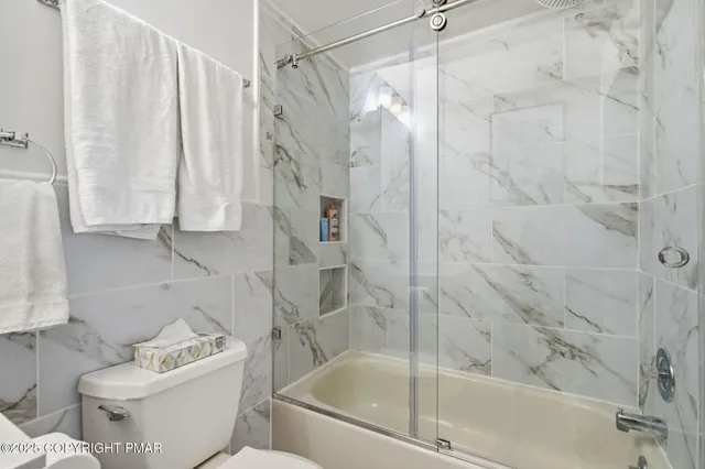 a bathroom with a granite countertop sink a toilet and mirror