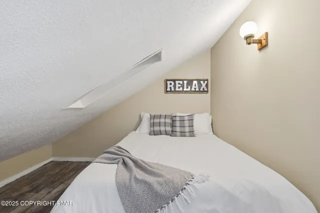 a bedroom with a large bed and wooden floor