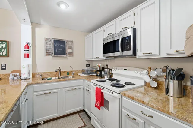 a living room with furniture a fireplace and a kitchen view