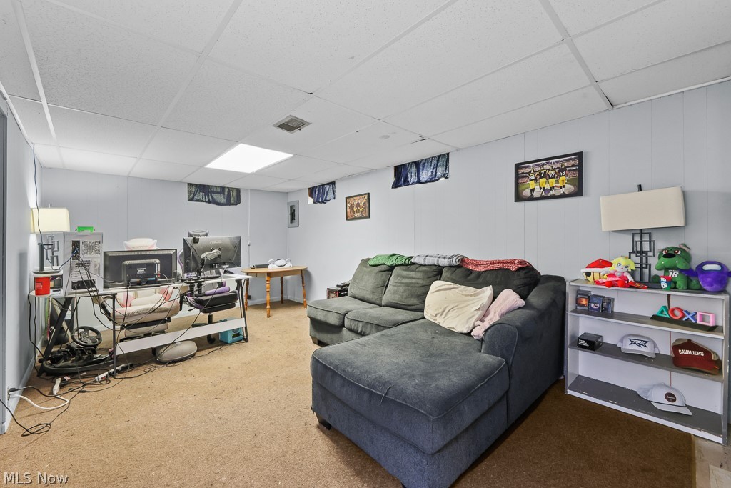611 Herbert Road Akron, OH 44312 - Photo 25 of 30 Carpeted room featuring light blue paneled walls and a grid drop ceiling