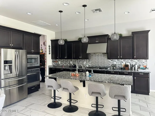 a kitchen with granite countertop a sink appliances and cabinets