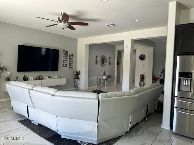 a living room with a flat screen tv a rug and white walls