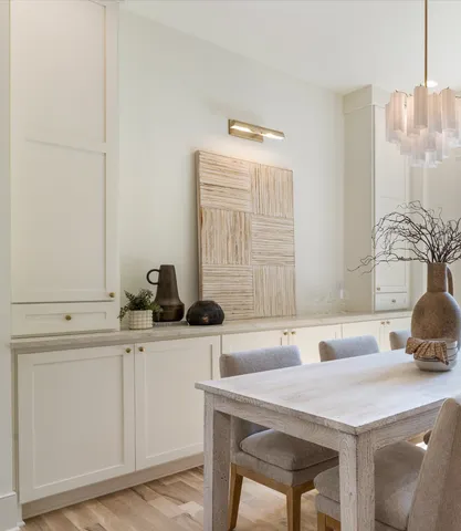 a kitchen with granite countertop a table chairs stove refrigerator and cabinets