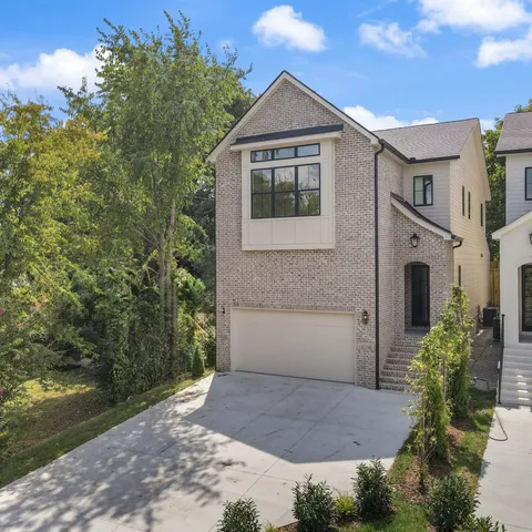 a front view of a house with a yard and trees
