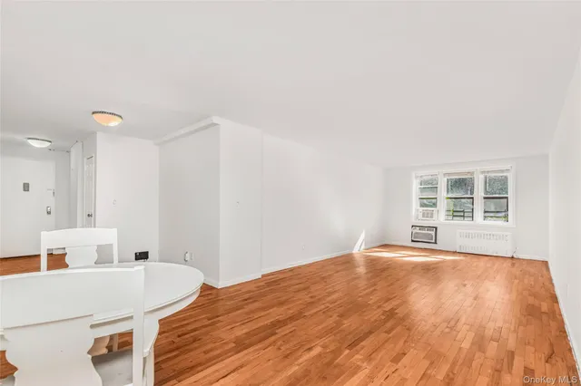 a view of a bedroom with a bed and wooden floor