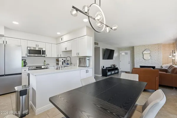 a kitchen with stainless steel appliances granite countertop a sink refrigerator stove and microwave