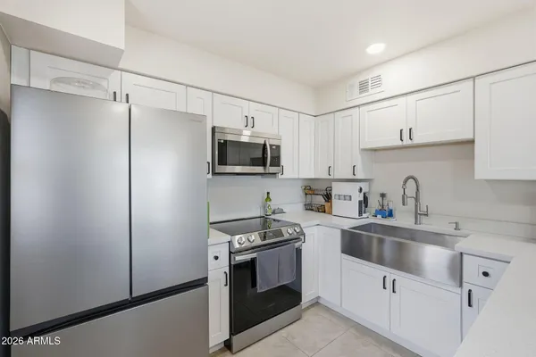 a kitchen with cabinets stainless steel appliances and a counter space