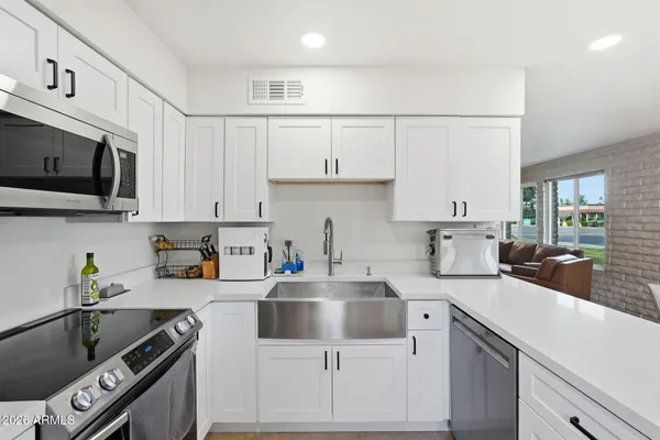 a kitchen with cabinets a sink and appliances