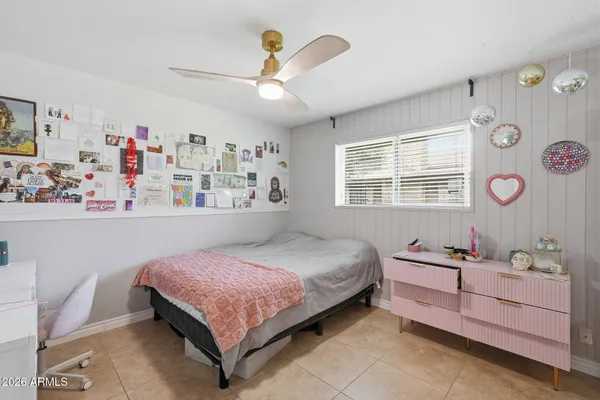 a bedroom with a bed dresser and window