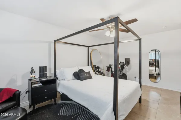 a bedroom with a bed a mirror and dresser