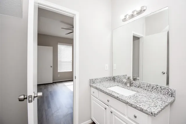 a bathroom with a granite countertop sink and a mirror
