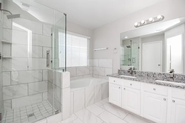 a bathroom with a granite countertop sink a mirror and a bathtub