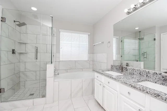 a bathroom with a granite countertop sink a large mirror and shower