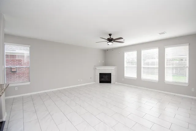 a view of an empty room with a fireplace and a window