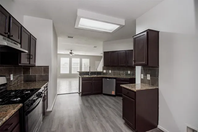 a kitchen with granite countertop stainless steel appliances and wooden cabinets