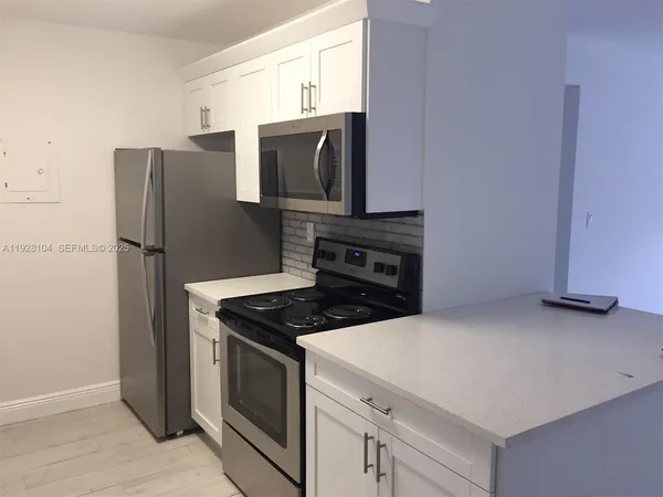 a kitchen with stainless steel appliances granite countertop a refrigerator stove and microwave