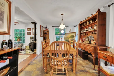 a view of a dining room with furniture a chandelier and large windows