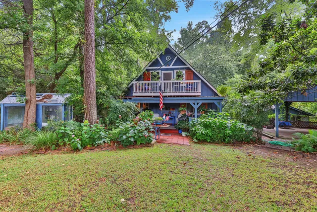 a view of backyard with potted plants and wooden fence