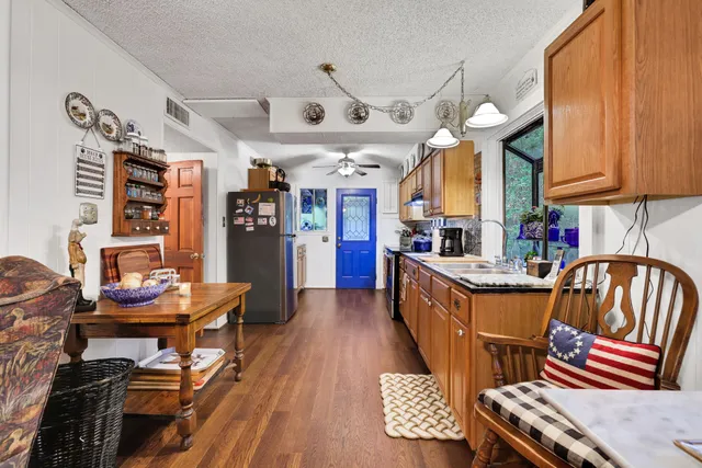 a living room with furniture a chandelier and a dining table with wooden floor