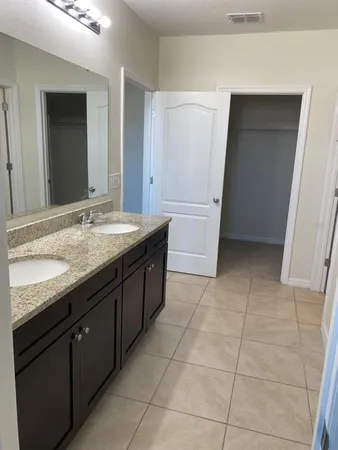 a bathroom with a granite countertop sink and mirror