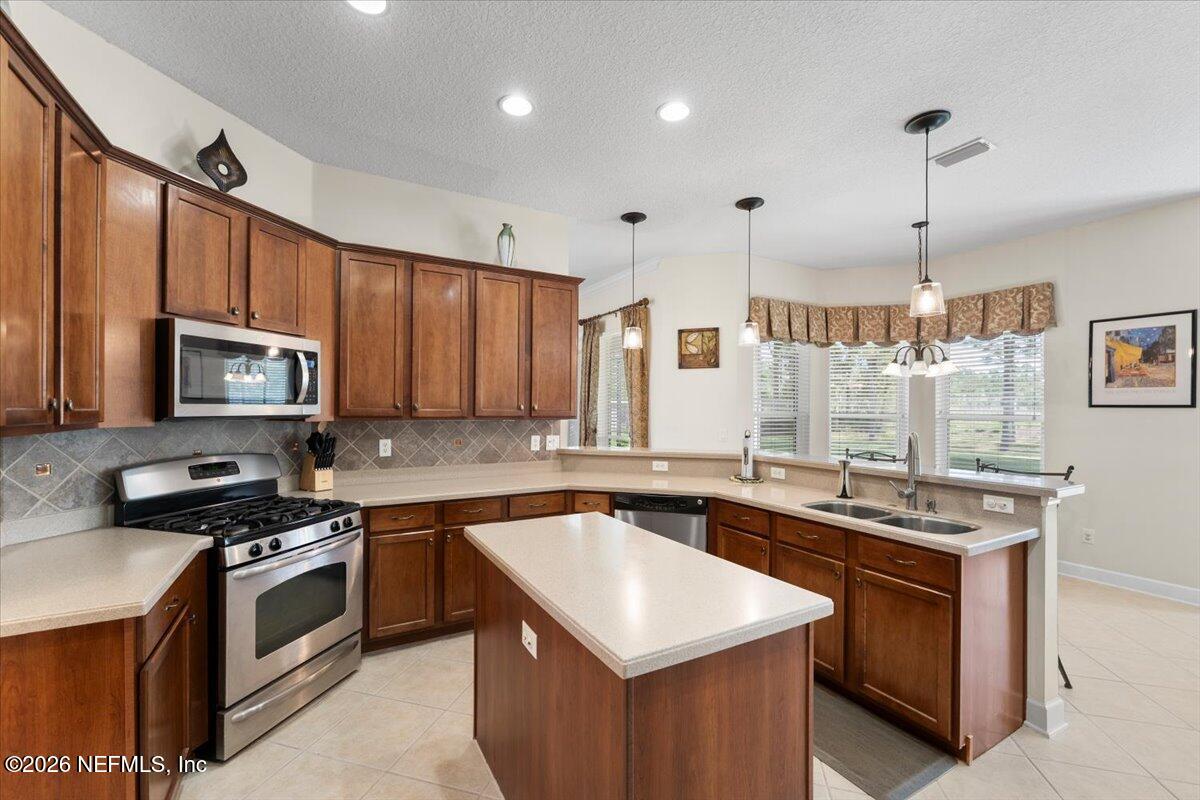 1112 Hawk Watch Circle St. Augustine, FL 32092 - Photo 17 of 49 a kitchen with stainless steel appliances a sink stove and microwave