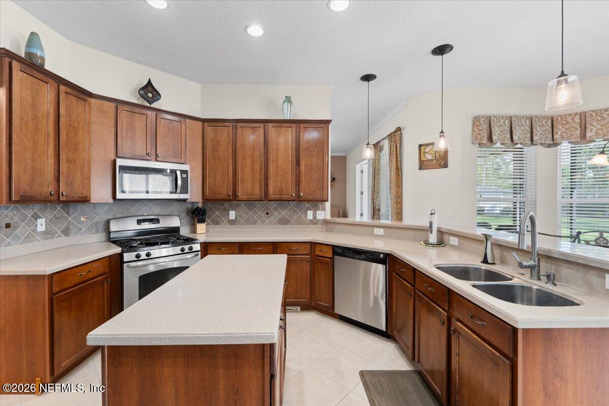 1112 Hawk Watch Circle St. Augustine, FL 32092 - Photo 18 of 49 a kitchen with stainless steel appliances granite countertop a sink stove and microwave