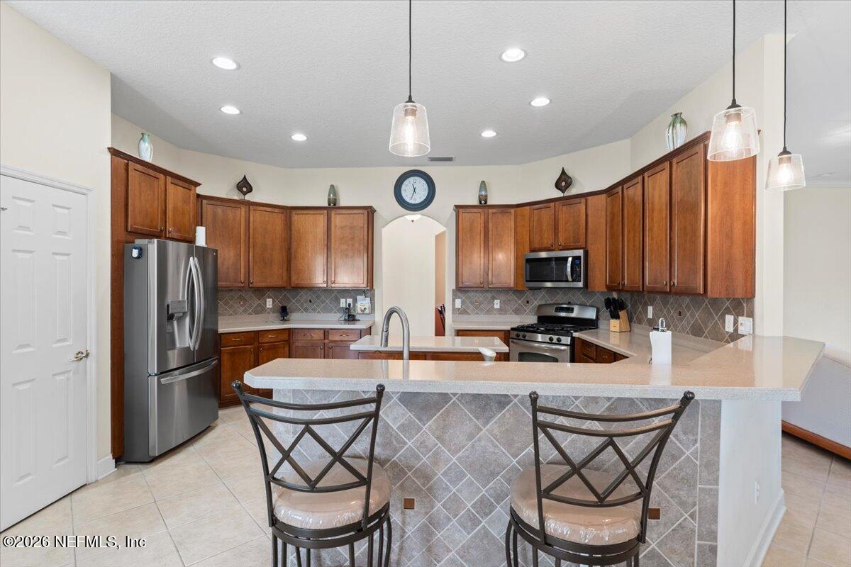 1112 Hawk Watch Circle St. Augustine, FL 32092 - Photo 21 of 49 a kitchen with stainless steel appliances granite countertop a sink a stove a refrigerator cabinets and chairs