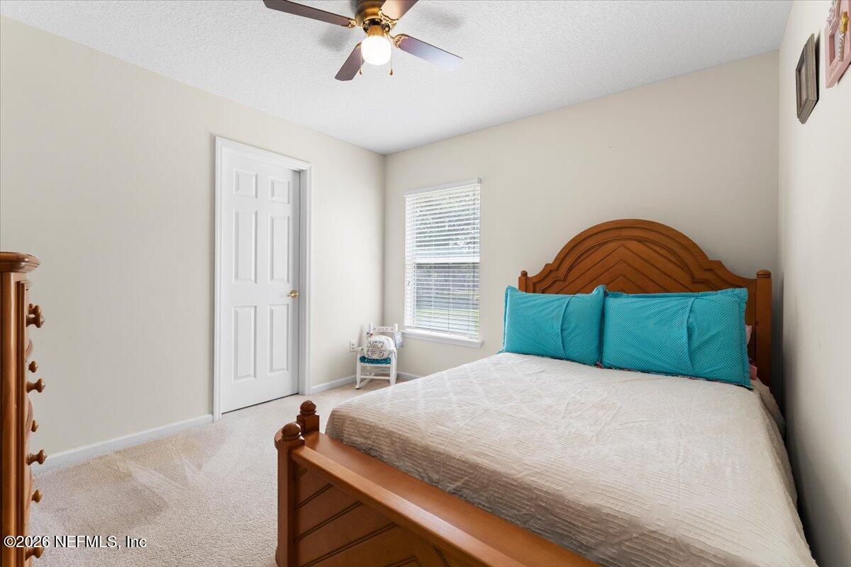1112 Hawk Watch Circle St. Augustine, FL 32092 - Photo 25 of 49 a bedroom with a bed and a chandelier