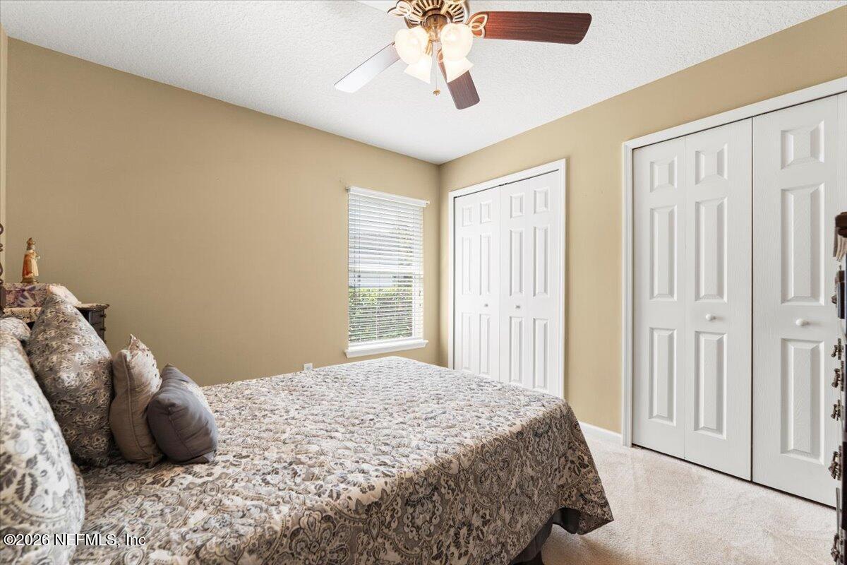 1112 Hawk Watch Circle St. Augustine, FL 32092 - Photo 28 of 49 a bedroom with a large bed and a chandelier fan