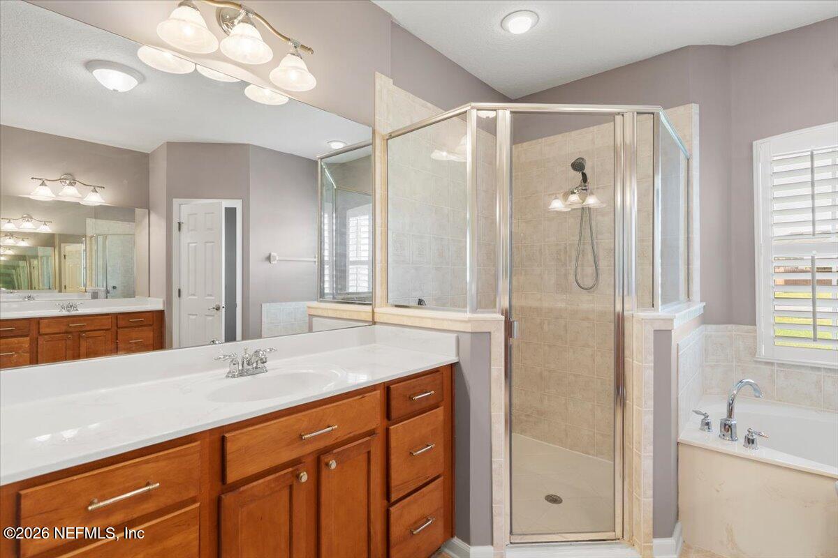 1112 Hawk Watch Circle St. Augustine, FL 32092 - Photo 35 of 49 a bathroom with a granite countertop sink mirror and shower
