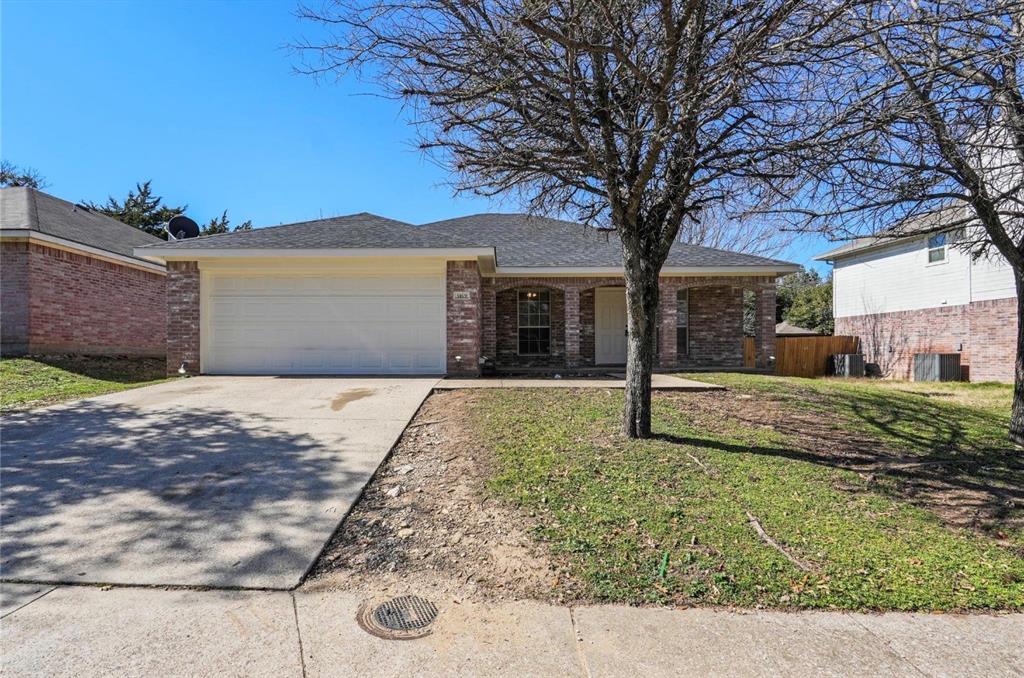 5169 East Rim Road Dallas, TX 75211 - Photo 19 of 19 Brick facade residence featuring an attached two-car garage with a concrete driveway