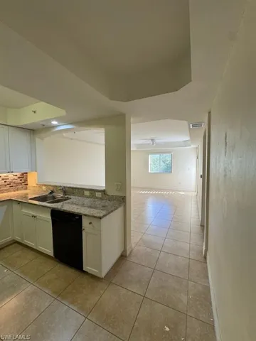 a large kitchen with granite countertop a stove top oven and cabinets