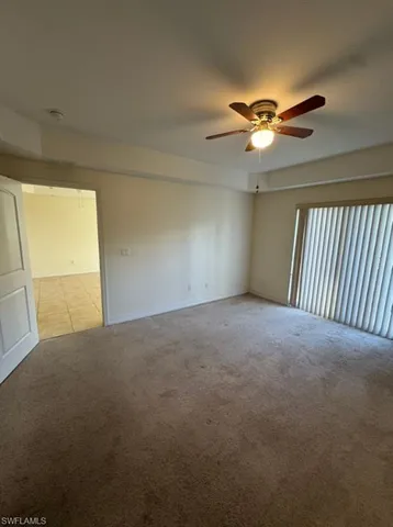 a view of a livingroom with a fan & a window