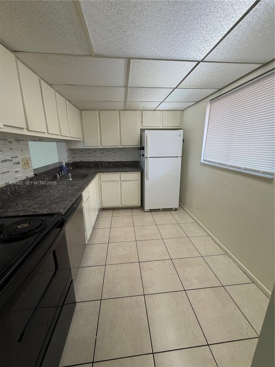 8600 Southwest 133rd Avenue Road, Unit 422 Miami, FL 33183 - Photo 3 of 9 a kitchen with a stove a sink and cabinets