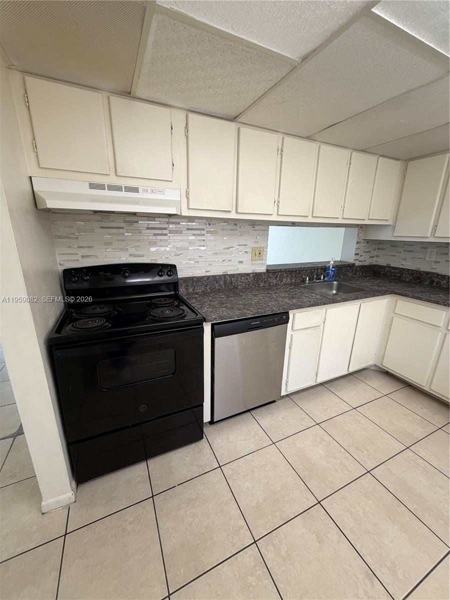 8600 Southwest 133rd Avenue Road, Unit 422 Miami, FL 33183 - Photo 7 of 9 a kitchen with granite countertop white cabinets and appliances