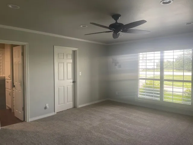 an empty room with windows and fan