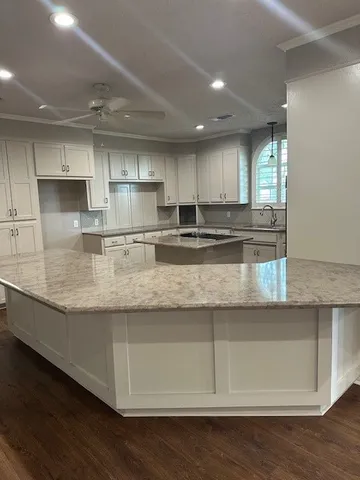 a view of a kitchen with center island and stainless steel appliances