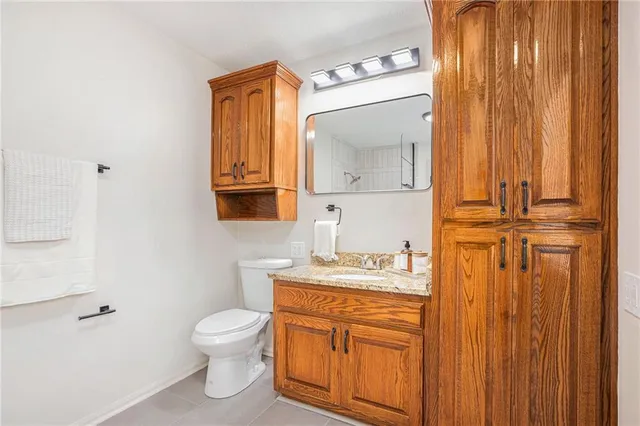 a bathroom with a toilet sink vanity and mirror