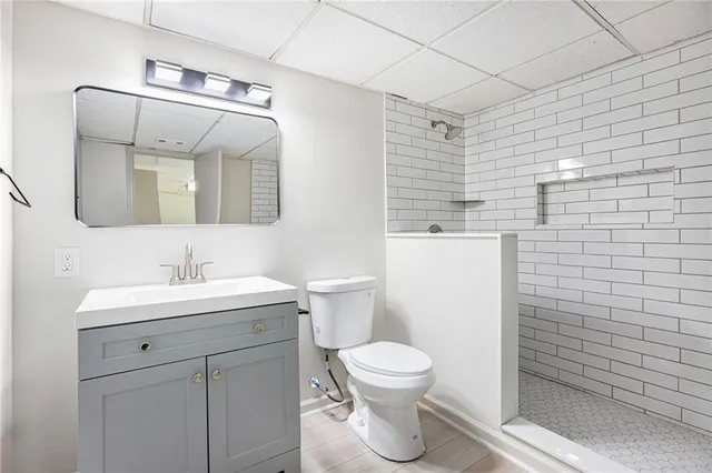 a bathroom with a toilet sink vanity and mirror