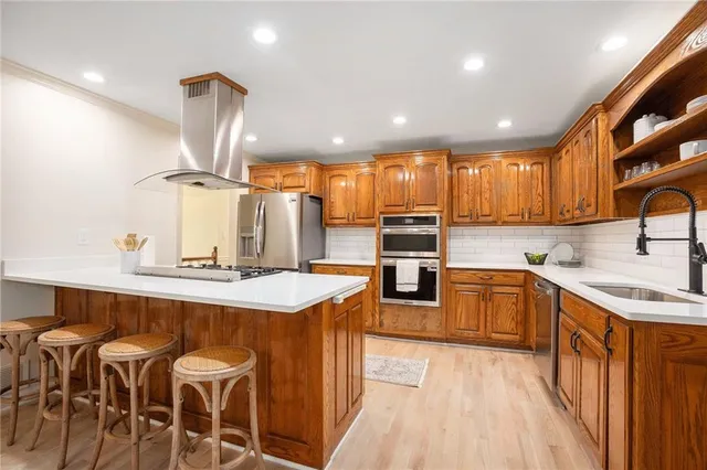a kitchen with stainless steel appliances granite countertop wooden cabinets and sink