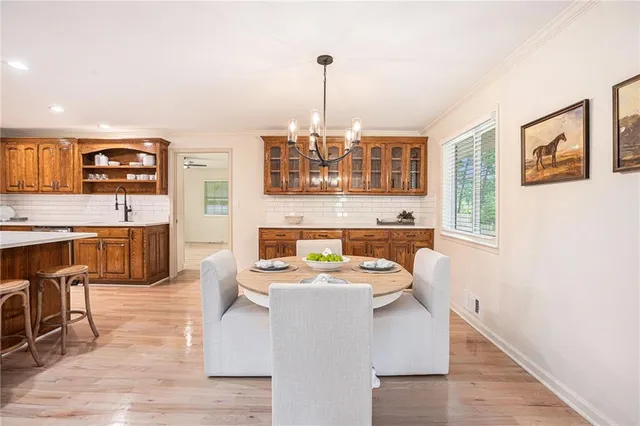 a living room with stainless steel appliances kitchen island granite countertop a stove a sink dishwasher and white cabinets with wooden floor