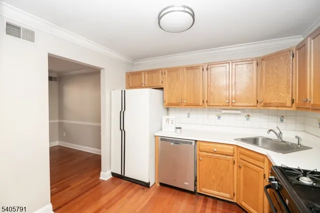 a kitchen with a refrigerator sink and cabinets