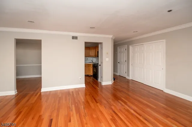 a view of an empty room with wooden floor