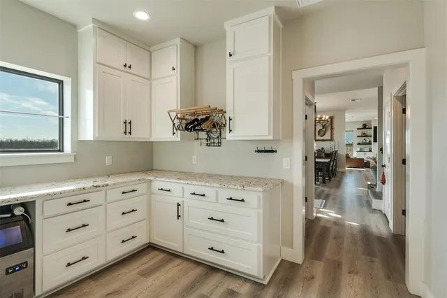 a kitchen with cabinets and wooden floor