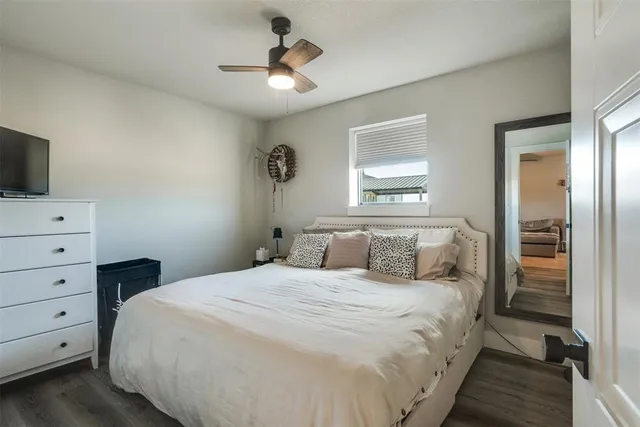 a bedroom with a bed a window and a flat screen television